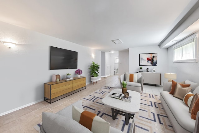 living room with a healthy amount of sunlight, light tile patterned flooring, and baseboards
