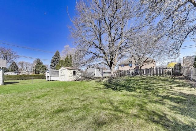 view of yard featuring a storage unit, a fenced backyard, and an outdoor structure