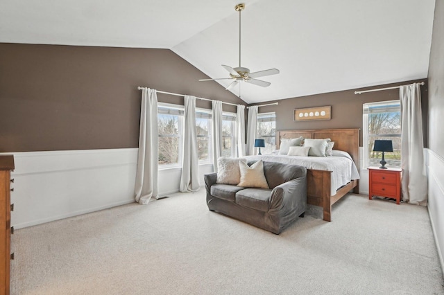 bedroom with a wainscoted wall, a ceiling fan, carpet, and vaulted ceiling