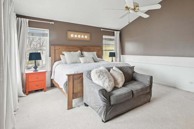 bedroom with carpet flooring, ceiling fan, wainscoting, and lofted ceiling