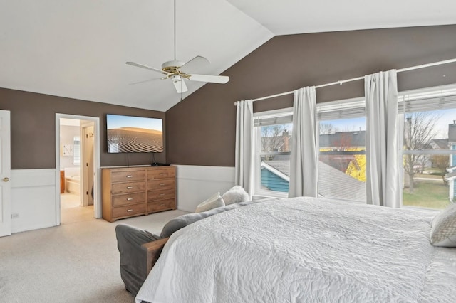 bedroom featuring ensuite bathroom, a ceiling fan, carpet flooring, wainscoting, and lofted ceiling