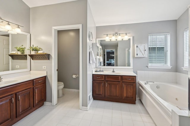 full bathroom featuring a sink, toilet, two vanities, and a jetted tub