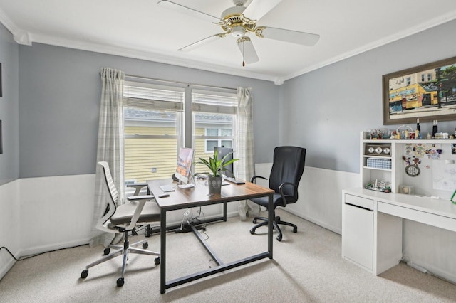 office area featuring light carpet, ornamental molding, ceiling fan, and wainscoting