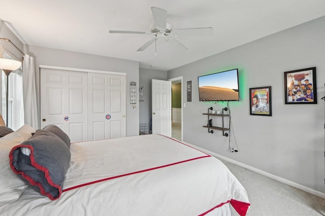 carpeted bedroom with a closet, baseboards, and ceiling fan