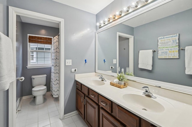bathroom featuring a sink, toilet, double vanity, and tile patterned flooring