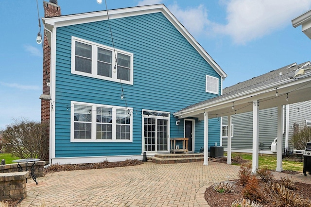 rear view of property featuring central AC, a patio, and a chimney