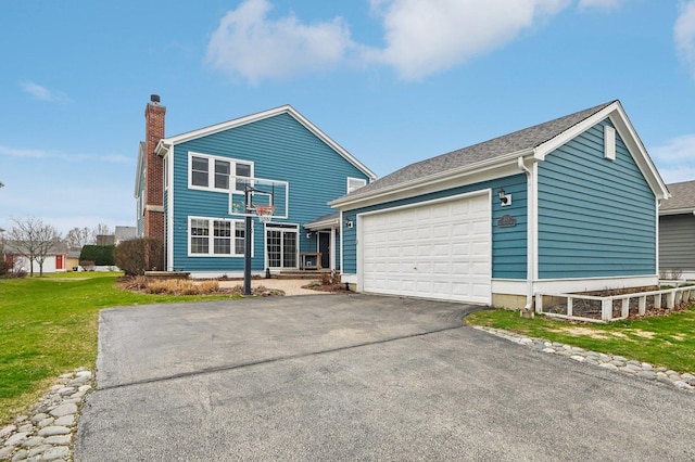 exterior space featuring a lawn, a chimney, a garage, aphalt driveway, and an outbuilding