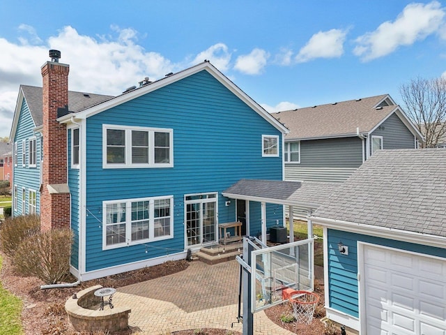 back of property with roof with shingles, an outdoor fire pit, a patio, and central air condition unit