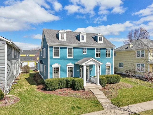 view of front of house with a front yard and roof with shingles