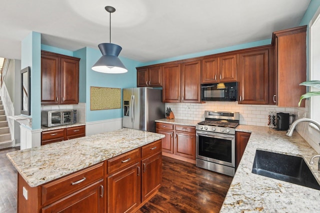 kitchen featuring a toaster, dark wood-style floors, light stone countertops, stainless steel appliances, and a sink