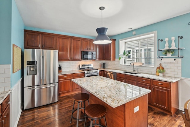 kitchen with a sink, light stone countertops, dark wood-style flooring, and stainless steel appliances