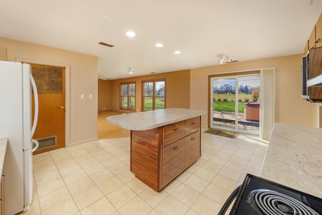 2S154 Lloyd Ave, Lombard, IL 60148 - kitchen with freestanding refrigerator, light tile patterned flooring, a center island, and light countertops