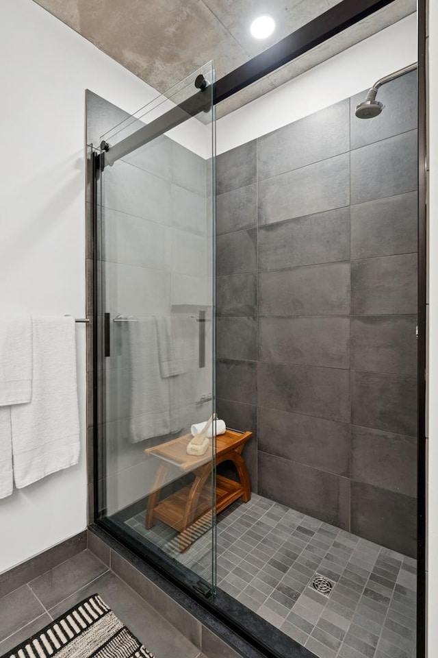 bathroom with a shower stall and tile patterned flooring