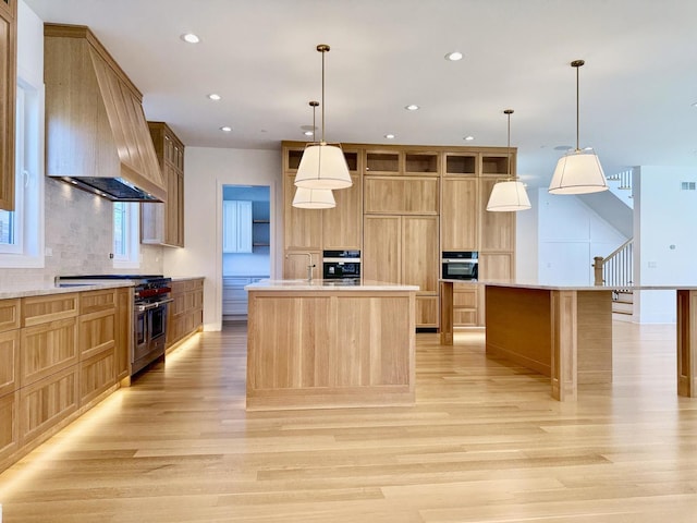 kitchen with premium range hood, an island with sink, high end stainless steel range, and wall oven
