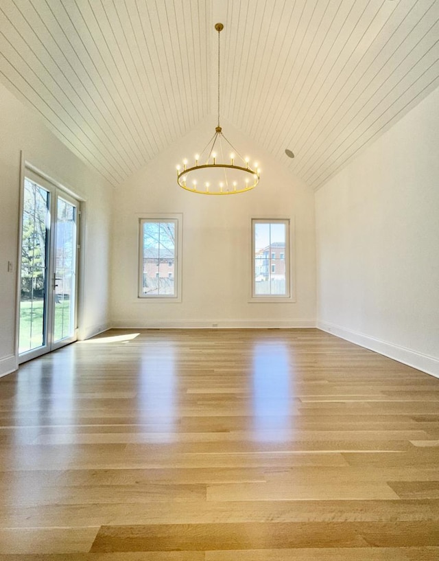 unfurnished dining area with light wood-style flooring, a chandelier, and a wealth of natural light