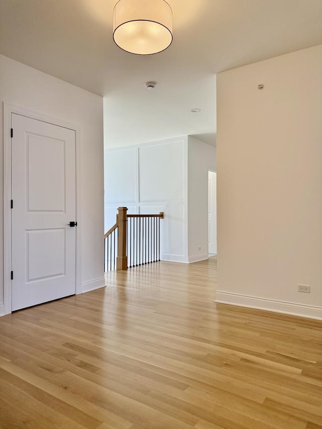 unfurnished room featuring baseboards and light wood-style floors