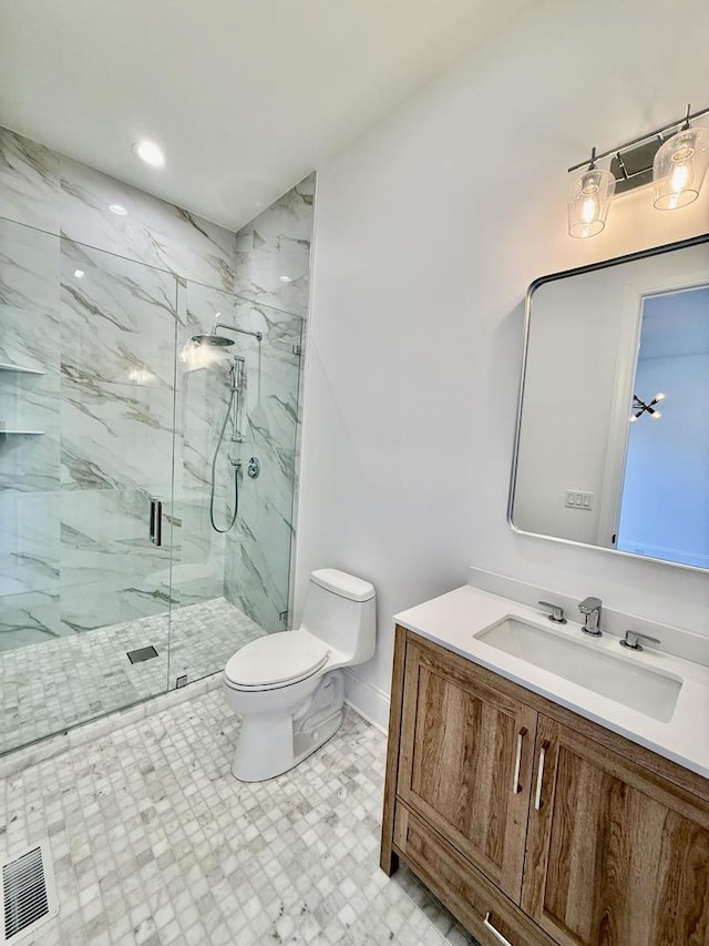 bathroom featuring vanity, visible vents, toilet, a marble finish shower, and baseboards