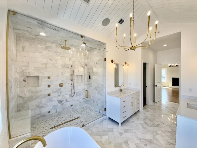 bathroom featuring a freestanding tub, vanity, a stall shower, a chandelier, and visible vents