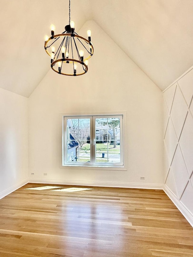 interior space featuring a chandelier, wood finished floors, and lofted ceiling