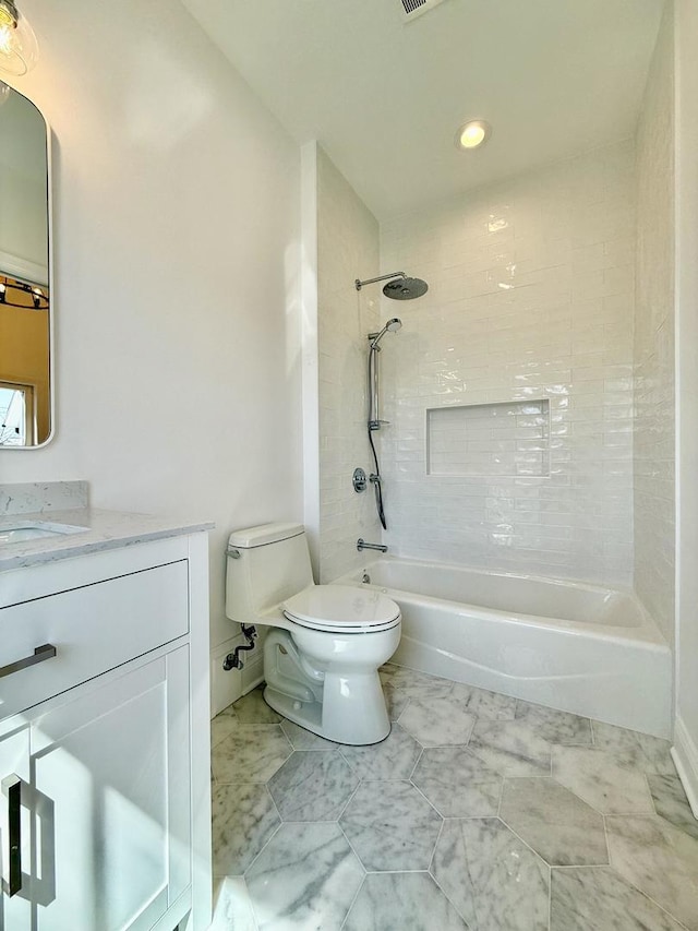 bathroom with toilet, marble finish floor, vanity, and tub / shower combination