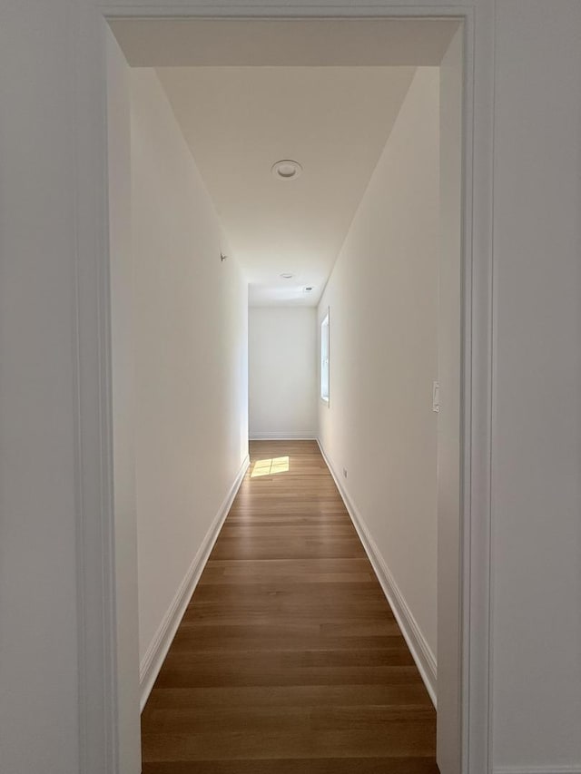 hallway with wood finished floors and baseboards