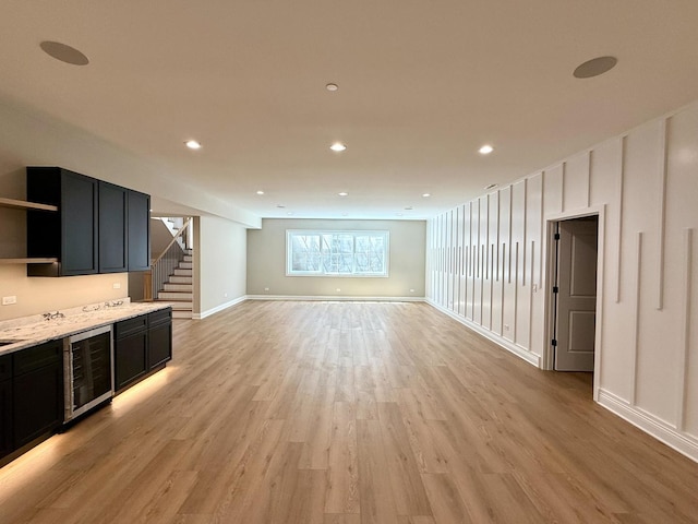 interior space with baseboards, wine cooler, stairway, recessed lighting, and light wood finished floors