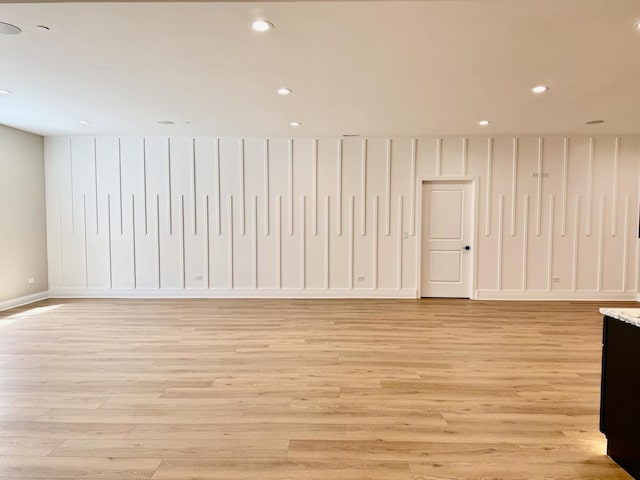 empty room featuring light wood-type flooring, baseboards, and recessed lighting