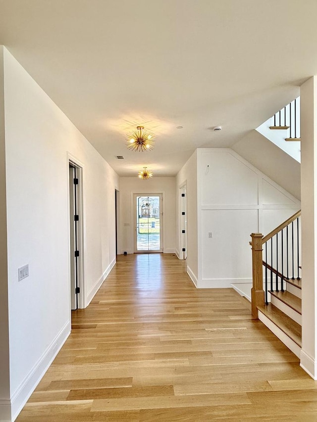 additional living space featuring stairs, light wood finished floors, and baseboards