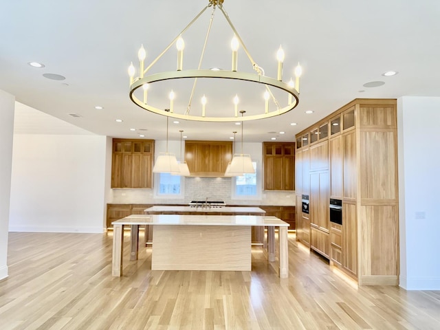 kitchen with tasteful backsplash, light countertops, a breakfast bar, a spacious island, and light wood-style flooring
