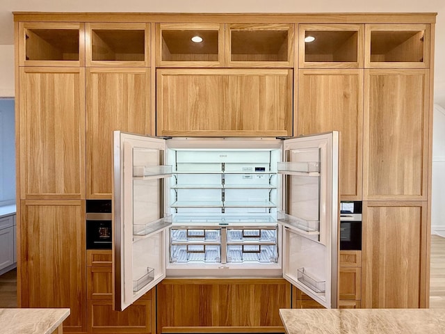 kitchen with wine cooler, light countertops, and glass insert cabinets