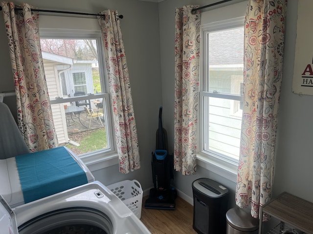 laundry room featuring baseboards, wood finished floors, laundry area, and plenty of natural light