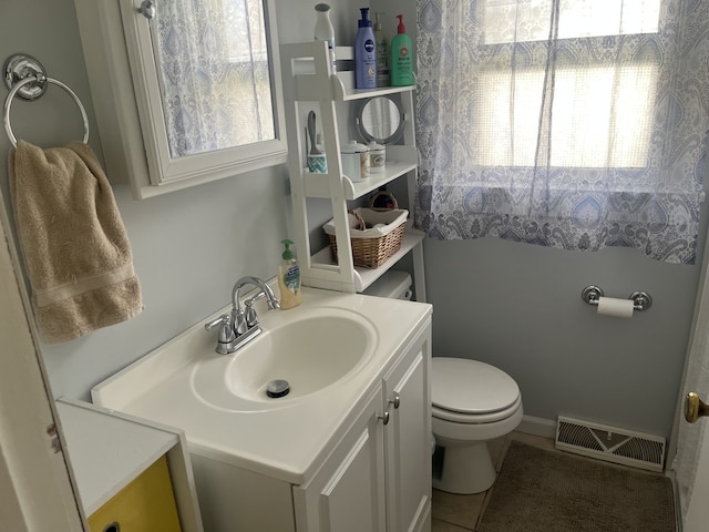 bathroom featuring plenty of natural light, visible vents, tile patterned floors, and toilet