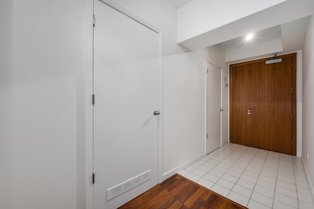 hall with light tile patterned flooring and visible vents