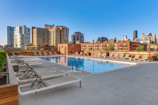 community pool with a patio and a view of city