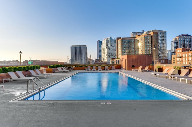 community pool with a city view and a patio area