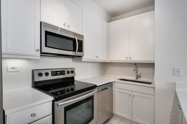 kitchen with white cabinets, light countertops, a sink, and appliances with stainless steel finishes