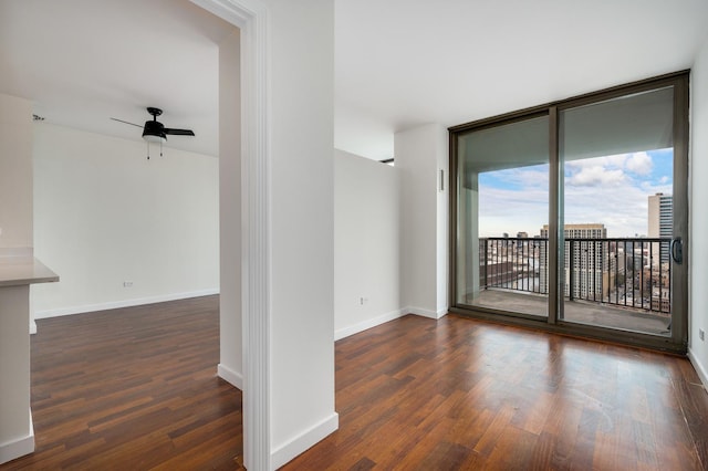 unfurnished room featuring wood finished floors, ceiling fan, and baseboards