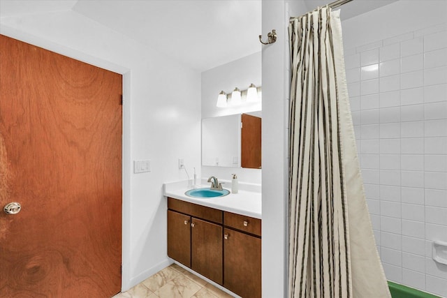 bathroom featuring marble look tile flooring, vanity, shower / bath combination with curtain, and baseboards