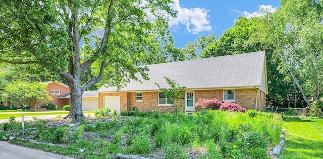 view of front of property with an attached garage, brick siding, a shingled roof, and a front lawn