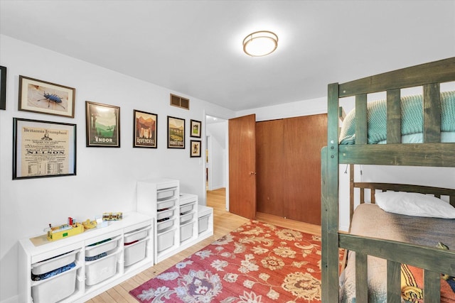 bedroom with wood finished floors and a closet