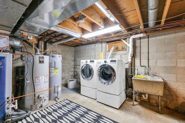 clothes washing area with gas water heater, water heater, and washer and dryer