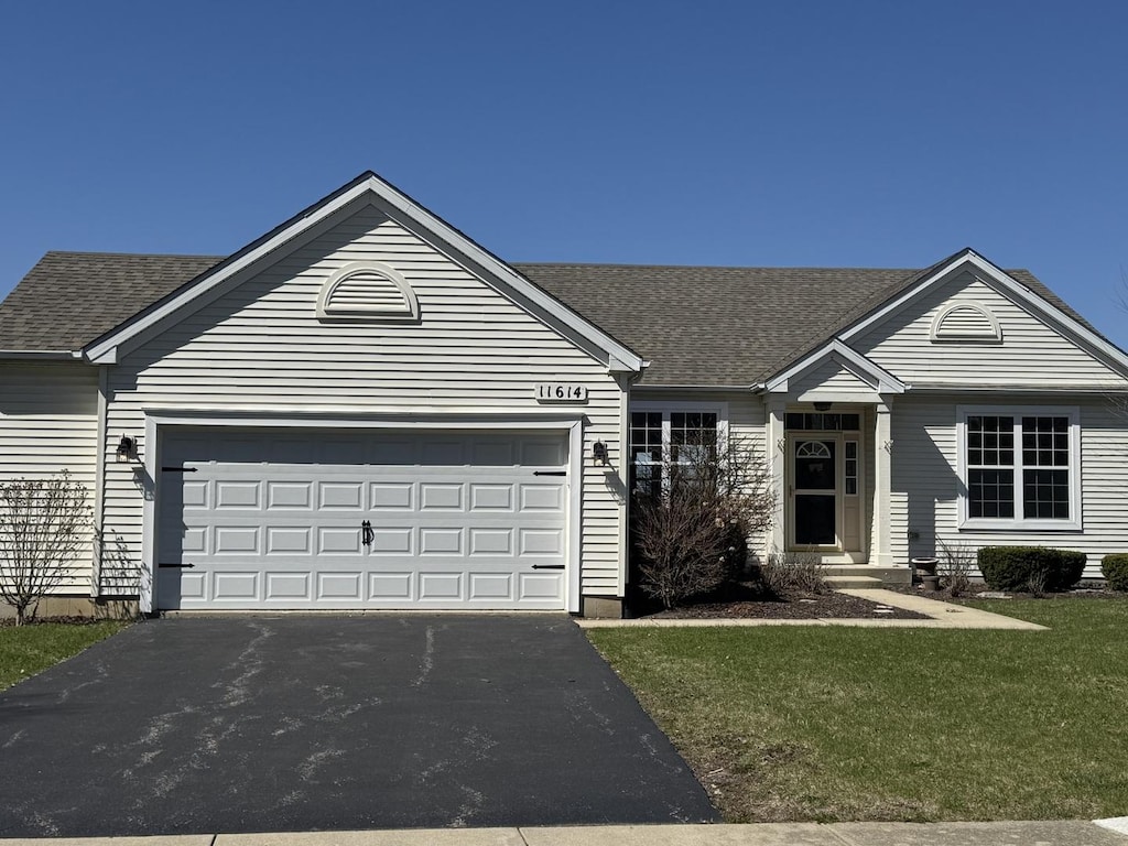 single story home with roof with shingles, driveway, an attached garage, and a front lawn
