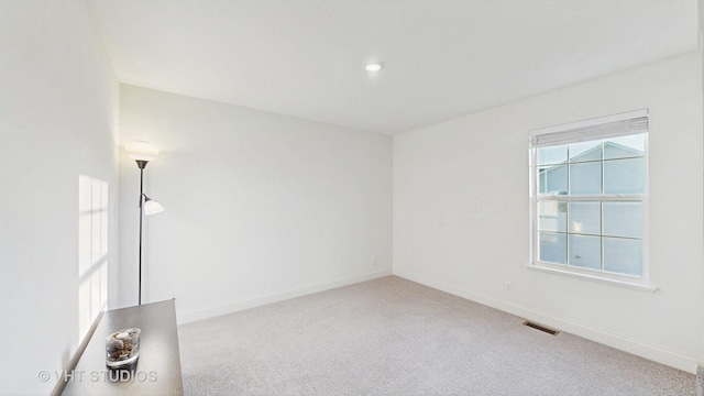 spare room featuring visible vents, baseboards, and carpet flooring