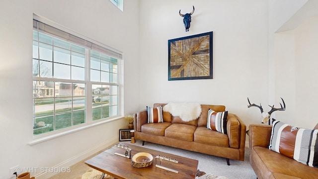 living area featuring a wealth of natural light, carpet flooring, and baseboards