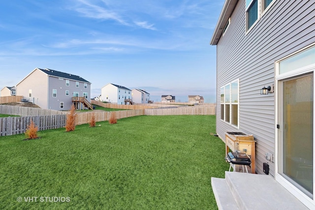 view of yard featuring a fenced backyard and a residential view