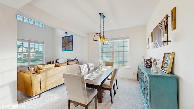 dining space with light colored carpet and baseboards