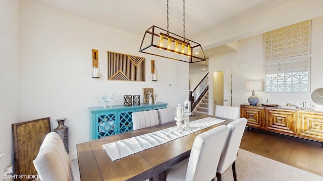 dining room with dark wood-style flooring and stairs