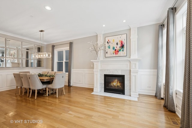 2733 N Maplewood Ave, Chicago, IL 60647 - dining room with light wood finished floors, wainscoting, a fireplace, and ornamental molding