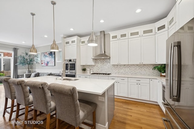 2733 N Maplewood Ave, Chicago, IL 60647 - kitchen featuring wall chimney exhaust hood, stainless steel appliances, a sink, a kitchen bar, and decorative backsplash