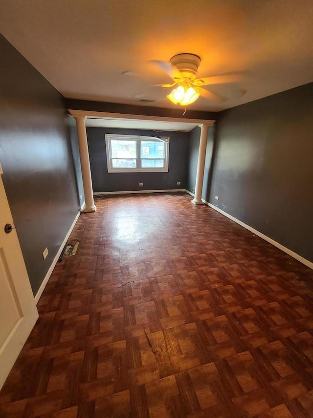 empty room featuring visible vents, baseboards, decorative columns, and a ceiling fan